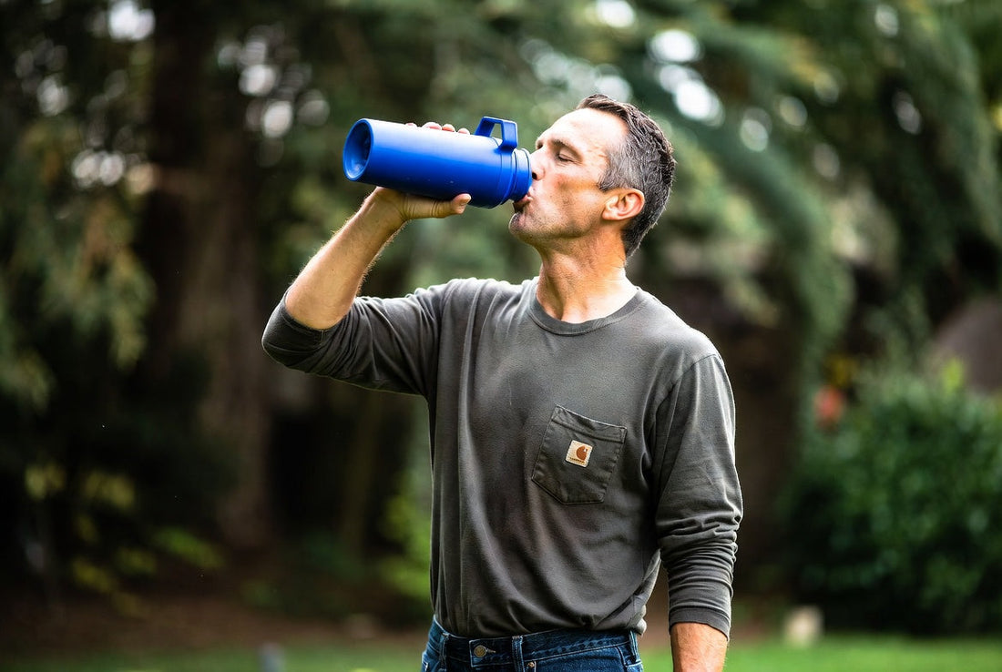 man drinking a homemade electrolyte drink for hydration during outdoor activity