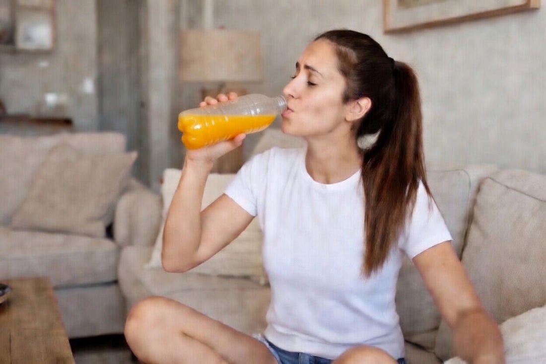 woman drinking a sports drink for hydration after exercise